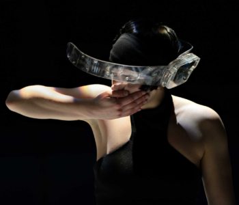 Motion sensing is integrated into all of the Prosthetic Instruments. Here Sophie Breton prepares to to whip her head around while wearing the Visor. This will send sound spinning throughout the performance space. Photo ©Michael Slobodian.